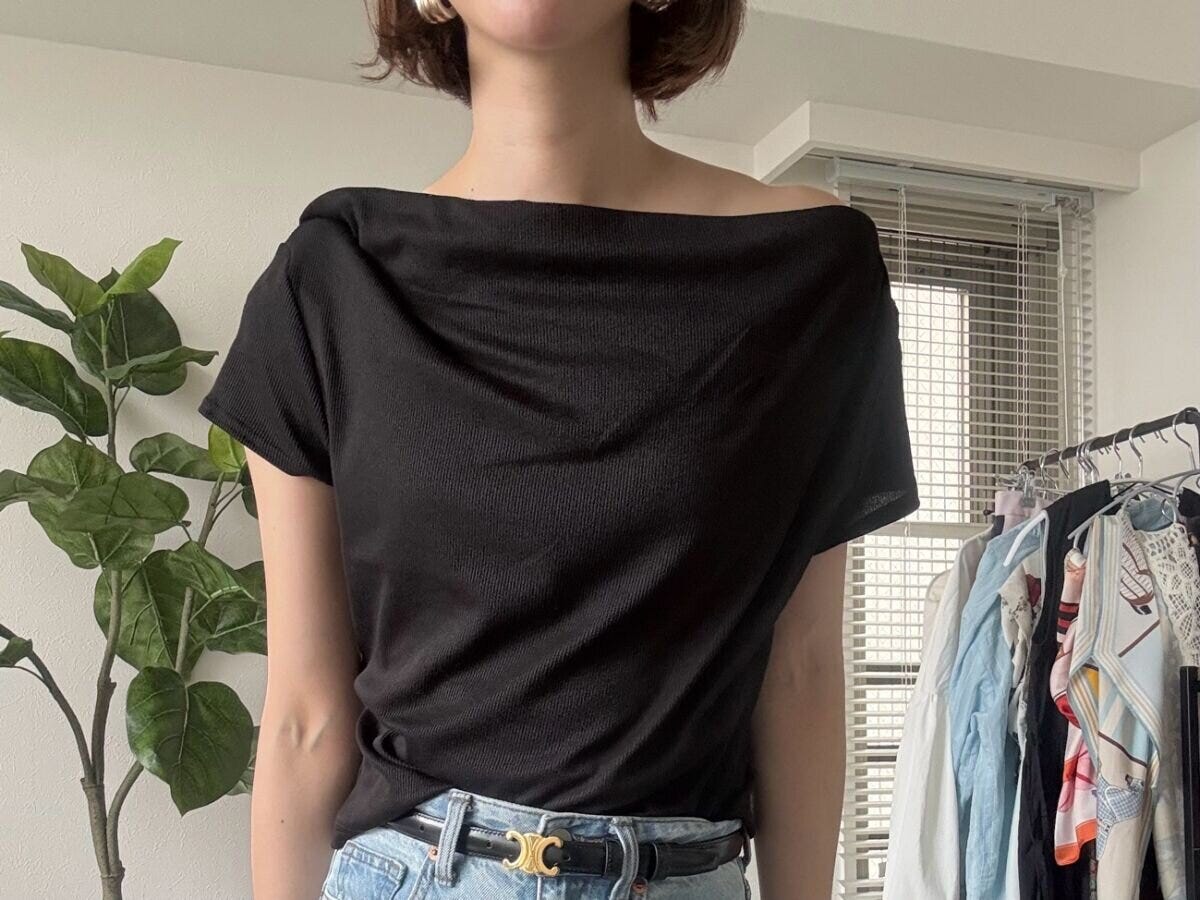 女性が黒のドレープネックTを肩を出さずに着用