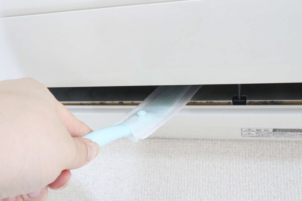 エアコンの吹き出し口にワイパーを差し込み掃除を始める様子