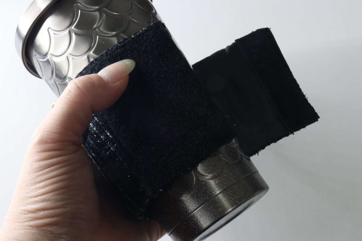 タンブラーにカップスリーブを巻き付けて面ファスナーで留めている手元 タンブラーにカップスリーブを巻き付けて面ファスナーで留めている手元