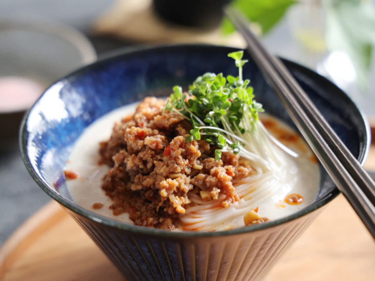 青い器に盛られた冷やし坦々そうめん。白いスープにひき肉とブロッコリースプラウトが乗っている。 青い器に盛られた冷やし坦々そうめん。白いスープにひき肉とブロッコリースプラウトが乗っている。