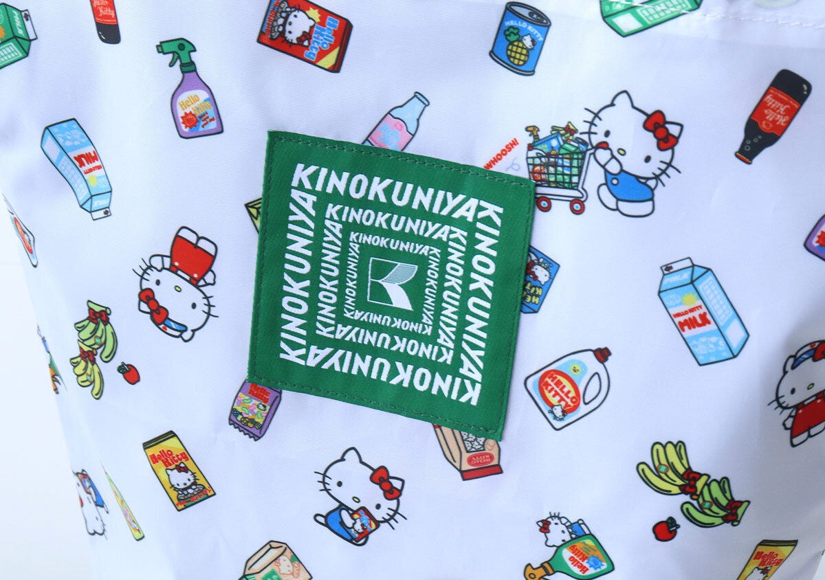 白地のバッグに縫い付けられた、緑色の紀ノ国屋ロゴの刺繍タグ