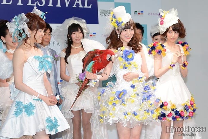 インコを腕にする白石麻衣(中央)、笑顔の松村沙友理(左)、怯える橋本奈々未(右)