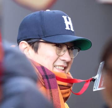 広島 熱烈カープファン・谷原章介がキャンプ地に コートの下にはユニ、手には選手名鑑のガチっぷり ブルペンで投手陣に熱視線