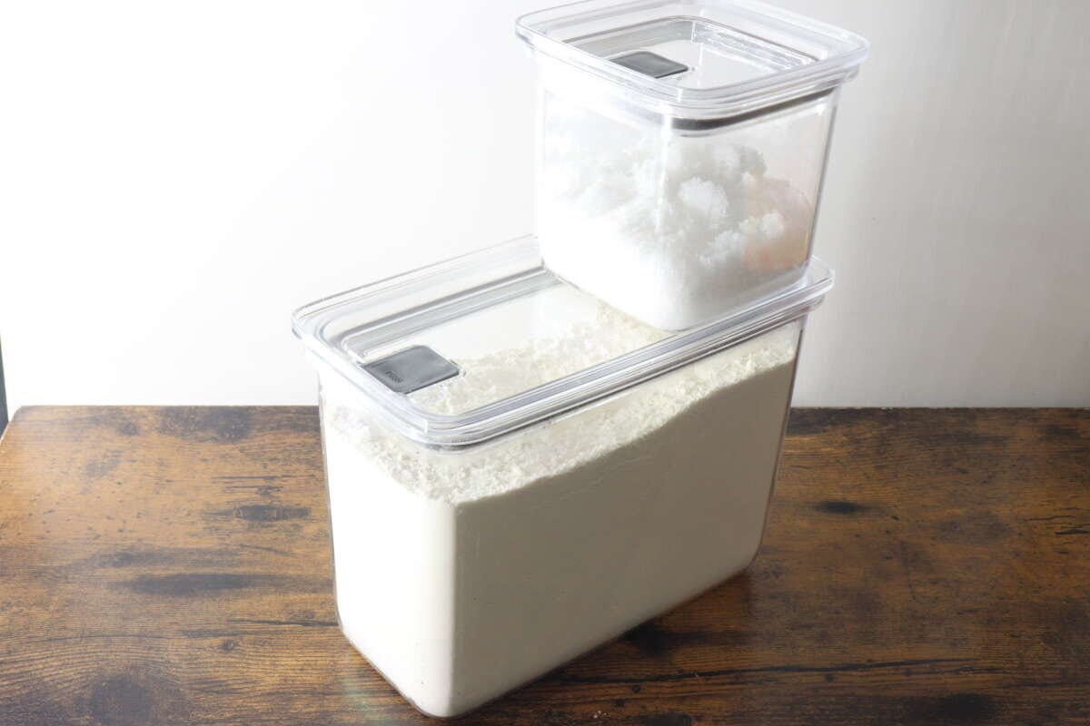 小麦粉の入った大きい容器の上に砂糖の入った小さい容器が重ねてある 小麦粉の入った大きい容器の上に砂糖の入った小さい容器が重ねてある