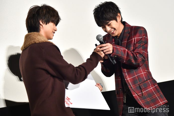 対決中にペンの蓋があかなくなってしまった高橋海人を助ける佐藤勝利 (C)モデルプレス