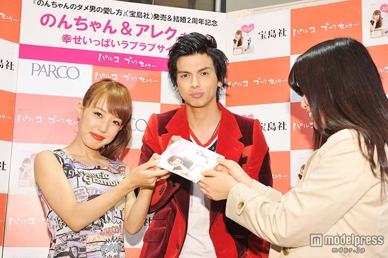 ファンに書籍を手渡しする川崎希、アレクサンダー