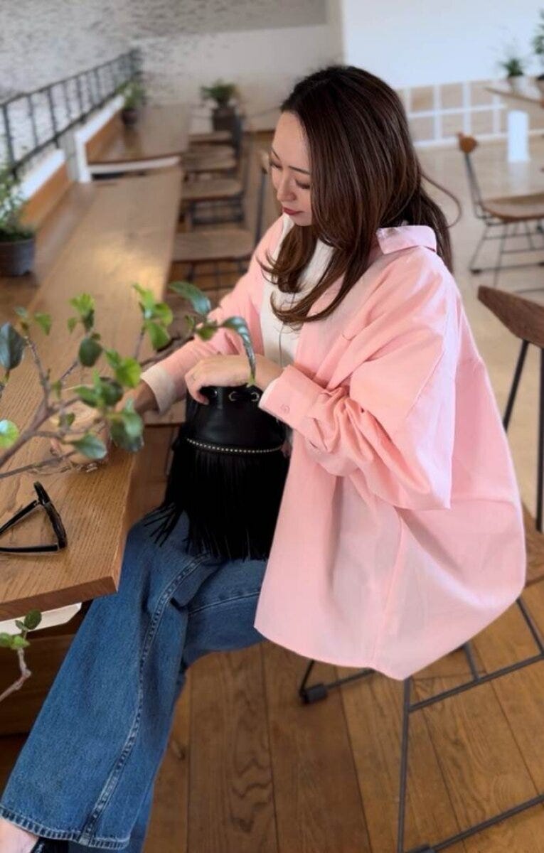 coca　シャツ　ピンク　デニム×黒バッグ大人カジュアルコーデ　カフェ座り