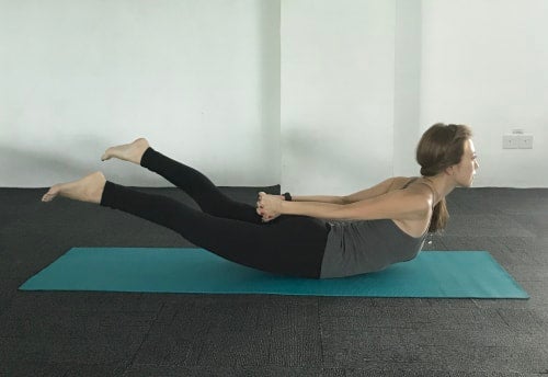 体の後ろで両手を握り、さらに肩甲骨を中央に寄せて胸を高く引き上げます。