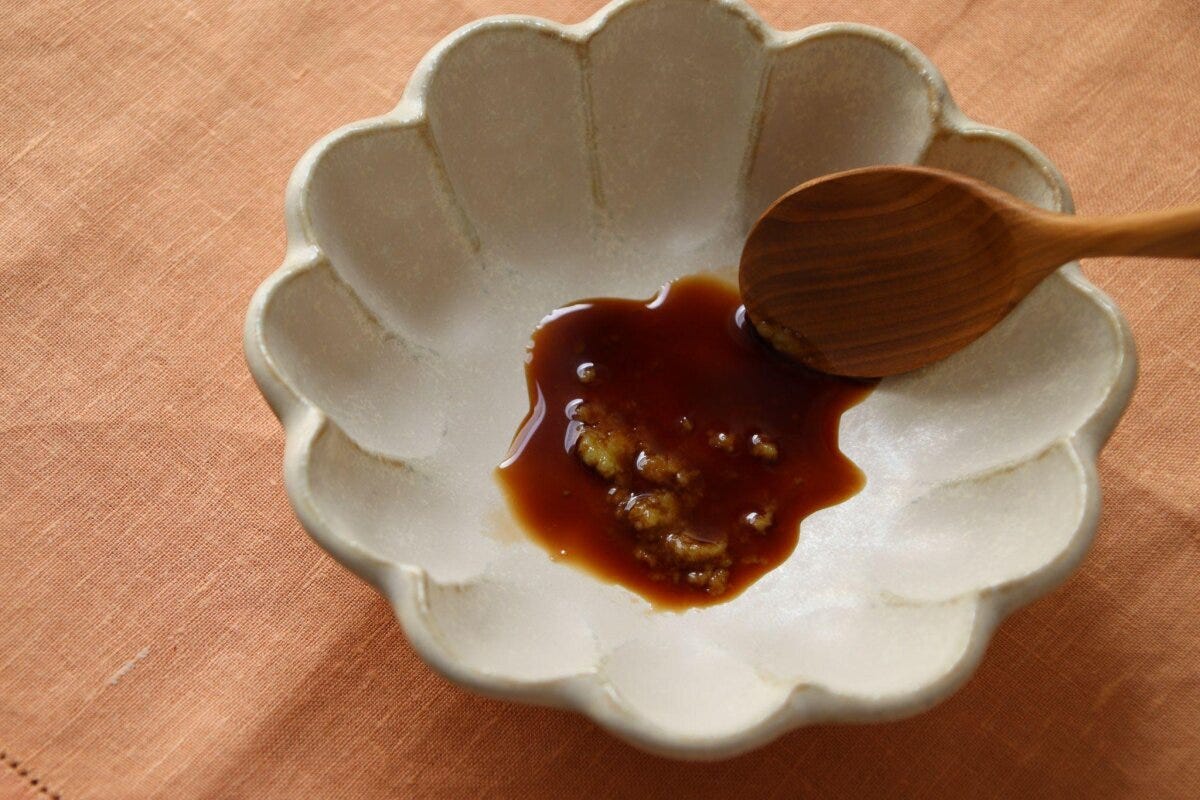 小皿に醤油とわさびを入れ、木のスプーンで混ぜている様子 小皿に醤油とわさびを入れ、木のスプーンで混ぜている様子