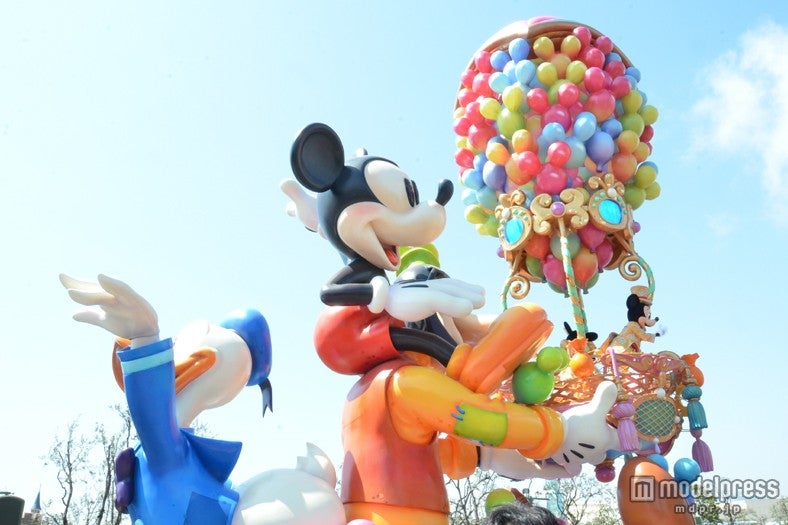 気球を支える大きなグーフィーと後ろに手を振るドナルド／ハピネス・イズ・ヒア