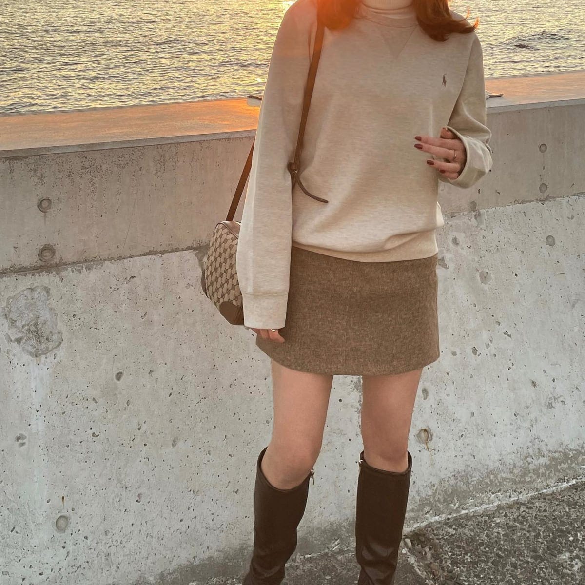 グレーのトレーナーとミニスカートを着た女性