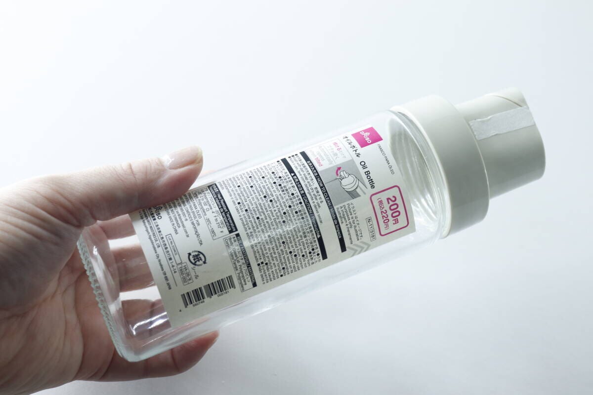 手で持ったダイソーのオイルボトル、商品ラベルが貼られた状態 手で持ったダイソーのオイルボトル、商品ラベルが貼られた状態