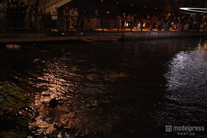 道頓堀川に飛び込んだ後、川を泳ぐ男性2人