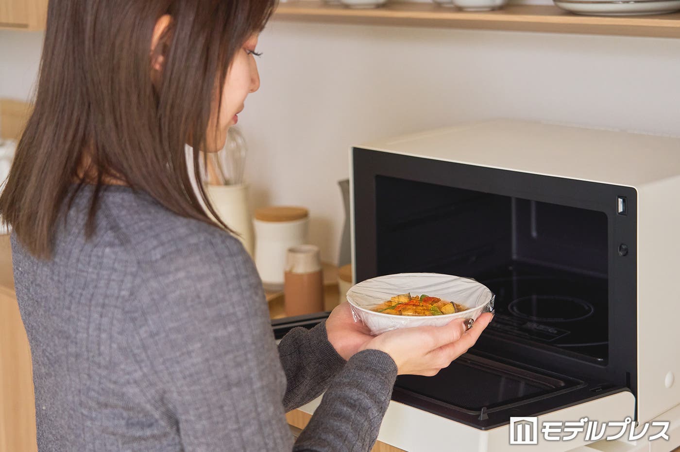 ラップをかけて、電子レンジで温めます。(C)モデルプレス