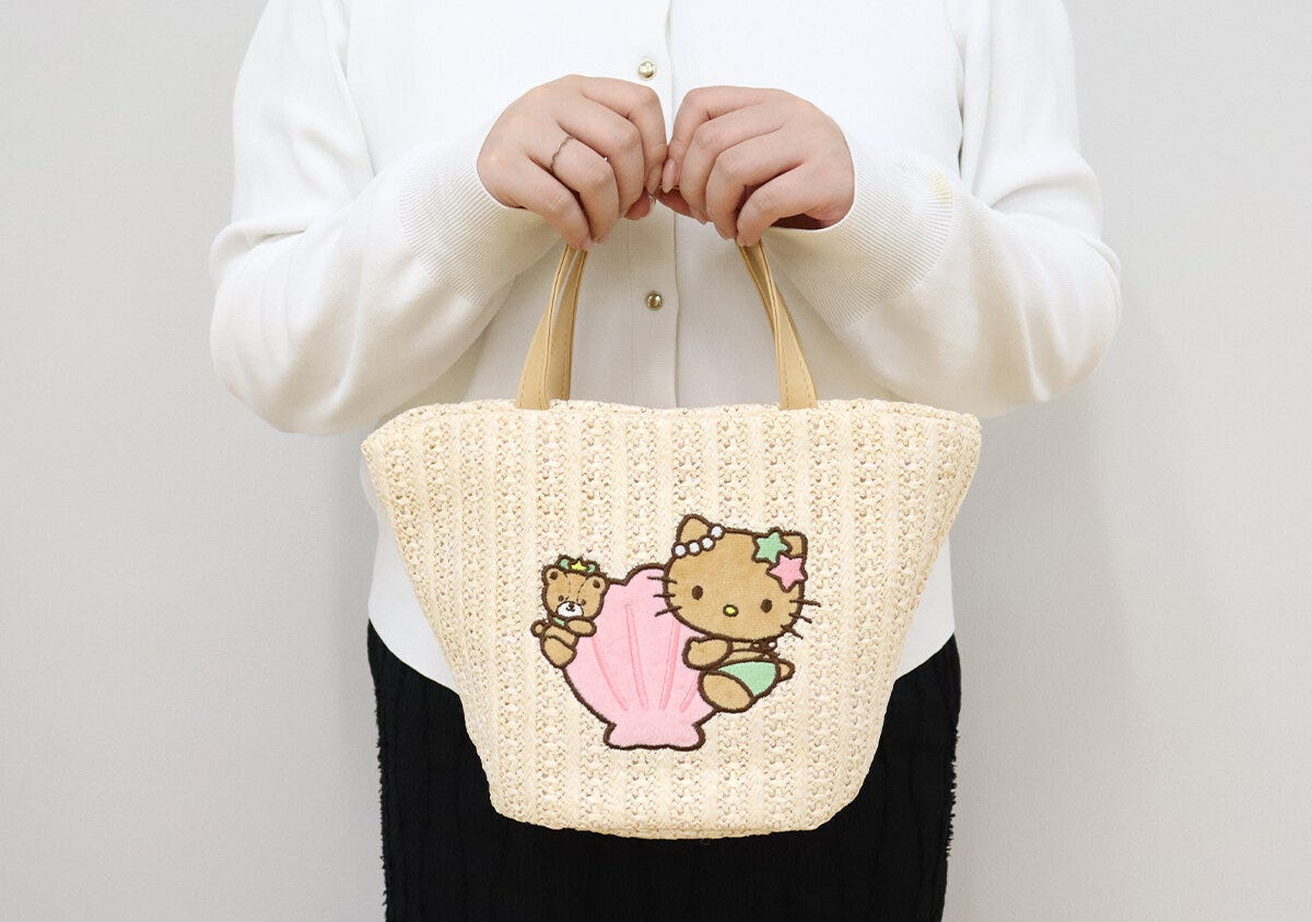 白い服を着た女性が日焼けハローキティのかごバッグを持っている