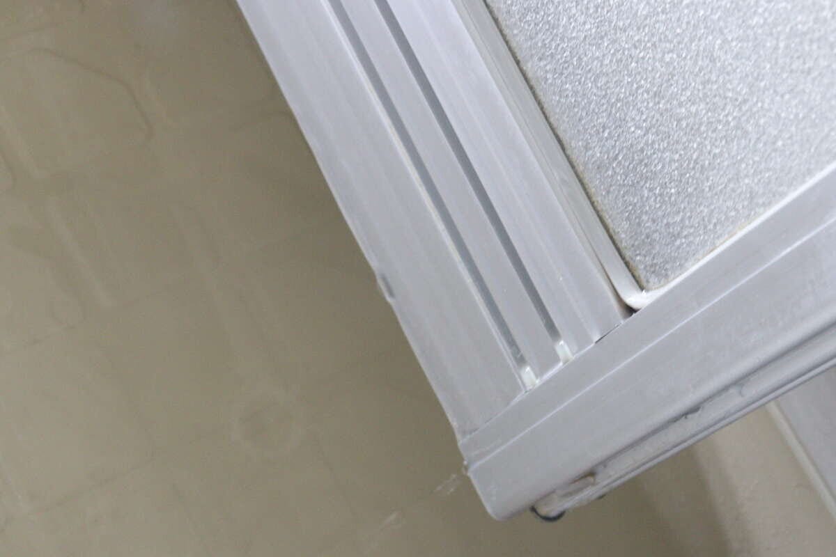 掃除後で汚れが落ちてきれいになった浴室ドアのレール