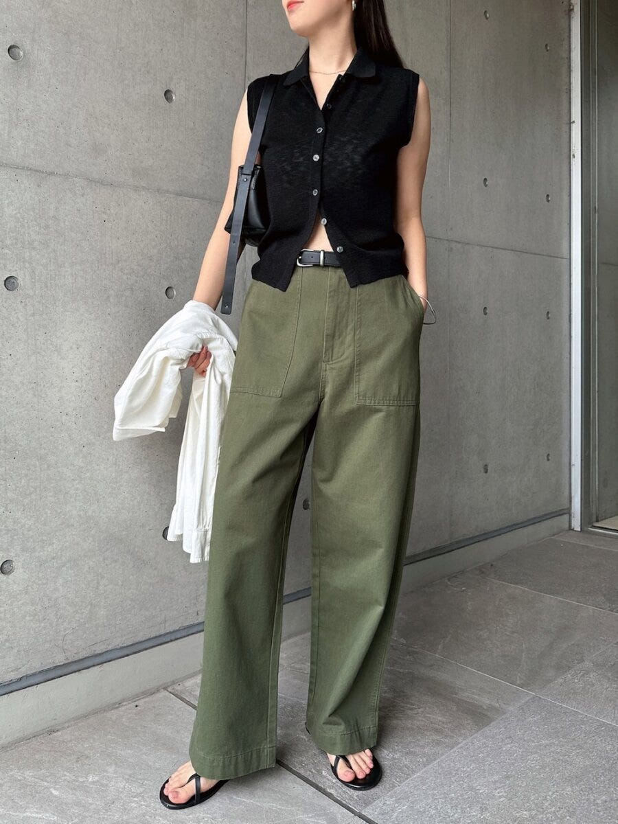 透け感黒ニットとカーキワイドパンツ、黒バッグを持った女性 透け感黒ニットとカーキワイドパンツ、黒バッグを持った女性