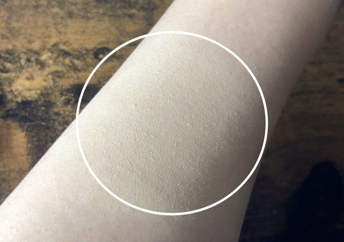 ファンデーションが塗布された女性の腕のアップ。自然な仕上がりで毛穴が目立たない ファンデーションが塗布された女性の腕のアップ。自然な仕上がりで毛穴が目立たない
