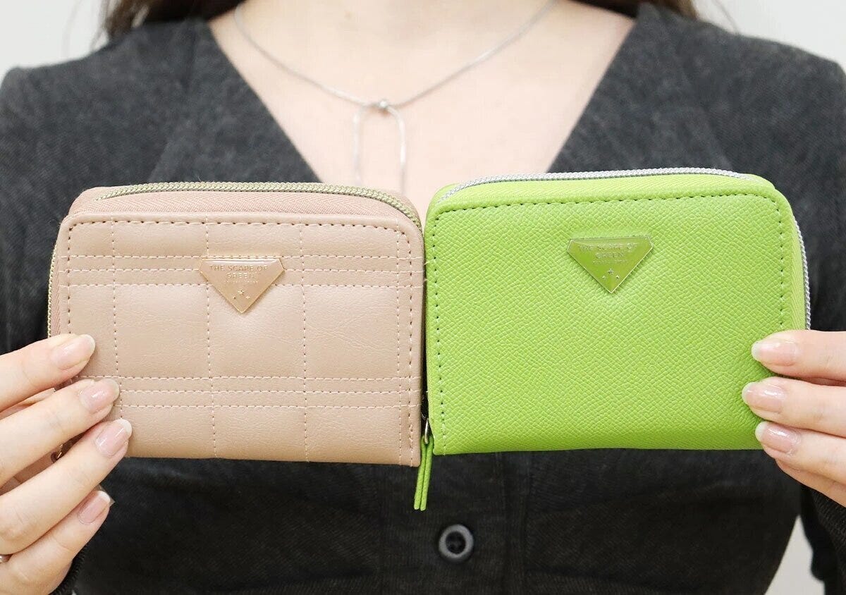 女性がピンクとアップルグリーンの2色のやみつきサイフを両手に持って見せている様子 女性がピンクとアップルグリーンの2色のやみつきサイフを両手に持って見せている様子