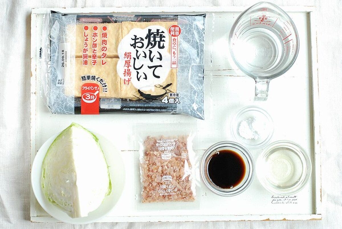 白いトレイに並べられた厚揚げ、キャベツ、調味料などの材料