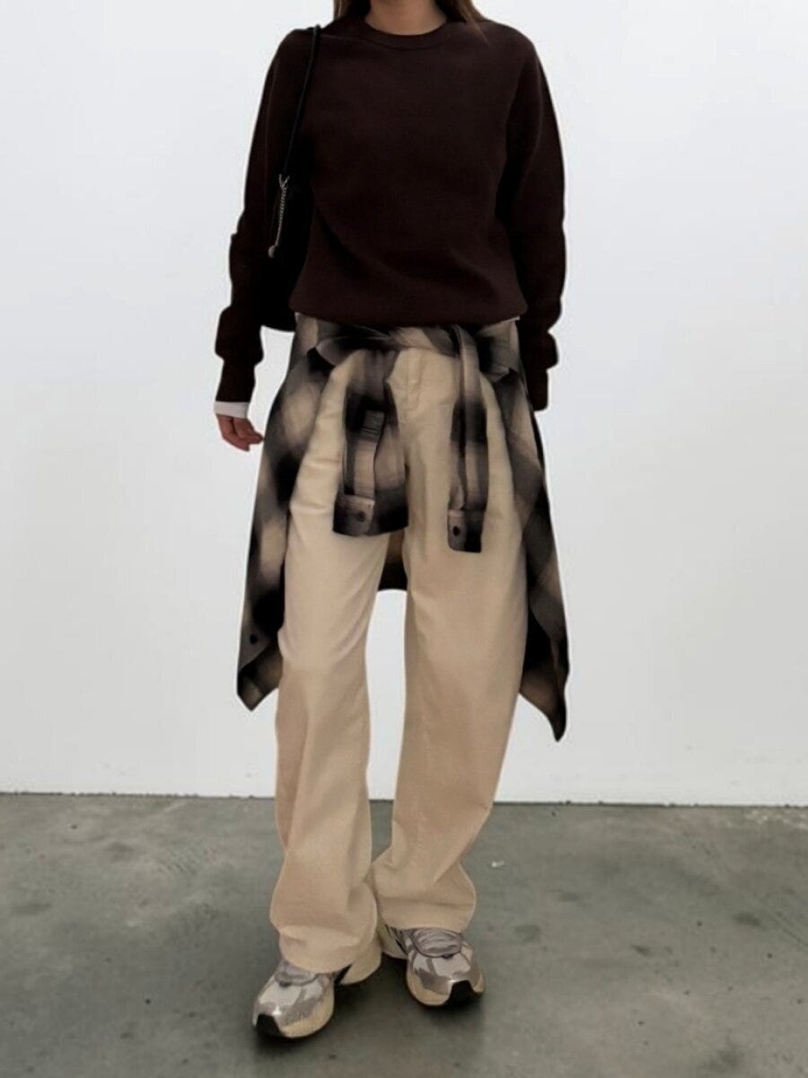 ベージュのバレルパンツにブラウンニットとチェックシャツ腰巻きのこなれ感ある女性の全身コーデ