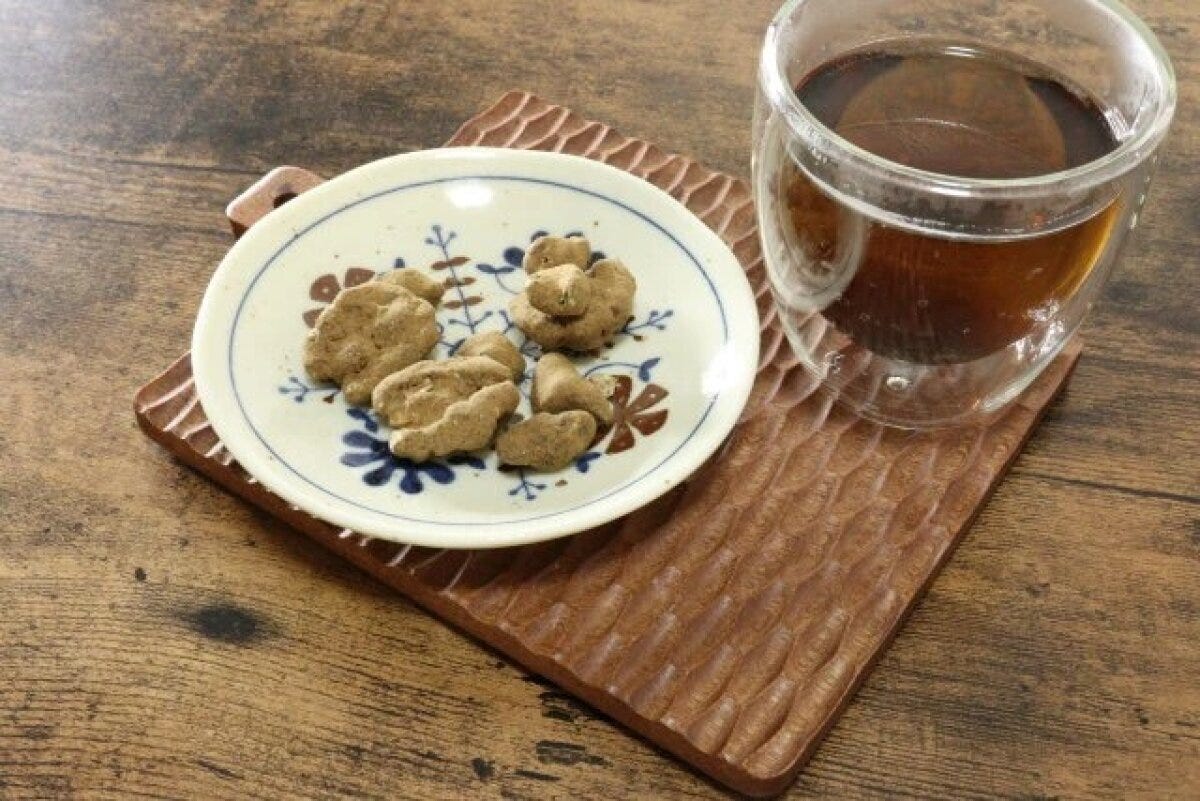 北欧風の小皿に茶色いお菓子が盛られ、隣にグラスの飲み物 北欧風の小皿に茶色いお菓子が盛られ、隣にグラスの飲み物