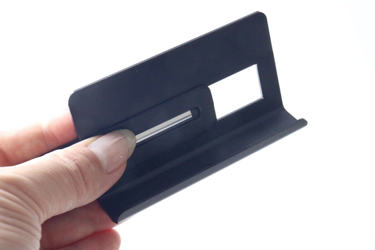 指で黒いスマホスタンドのパーツを組み立てている様子。
