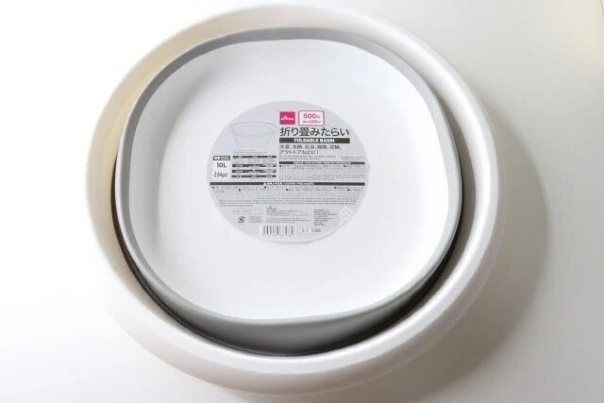 白い折り畳みたらいが畳まれ商品ラベルが見える状態 白い折り畳みたらいが畳まれ商品ラベルが見える状態