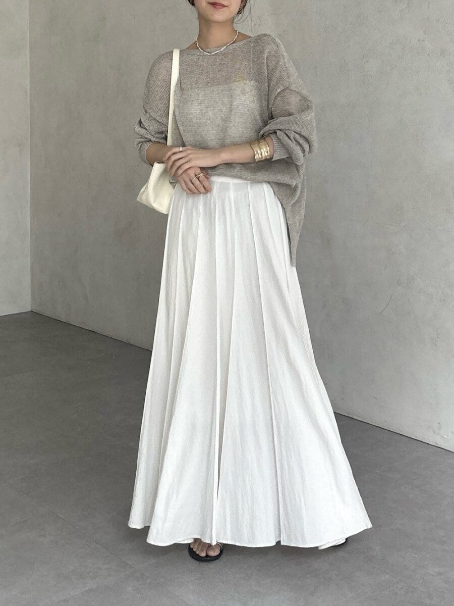 グレージュの透け感ニットと白フレアスカートでフェミニンな女性