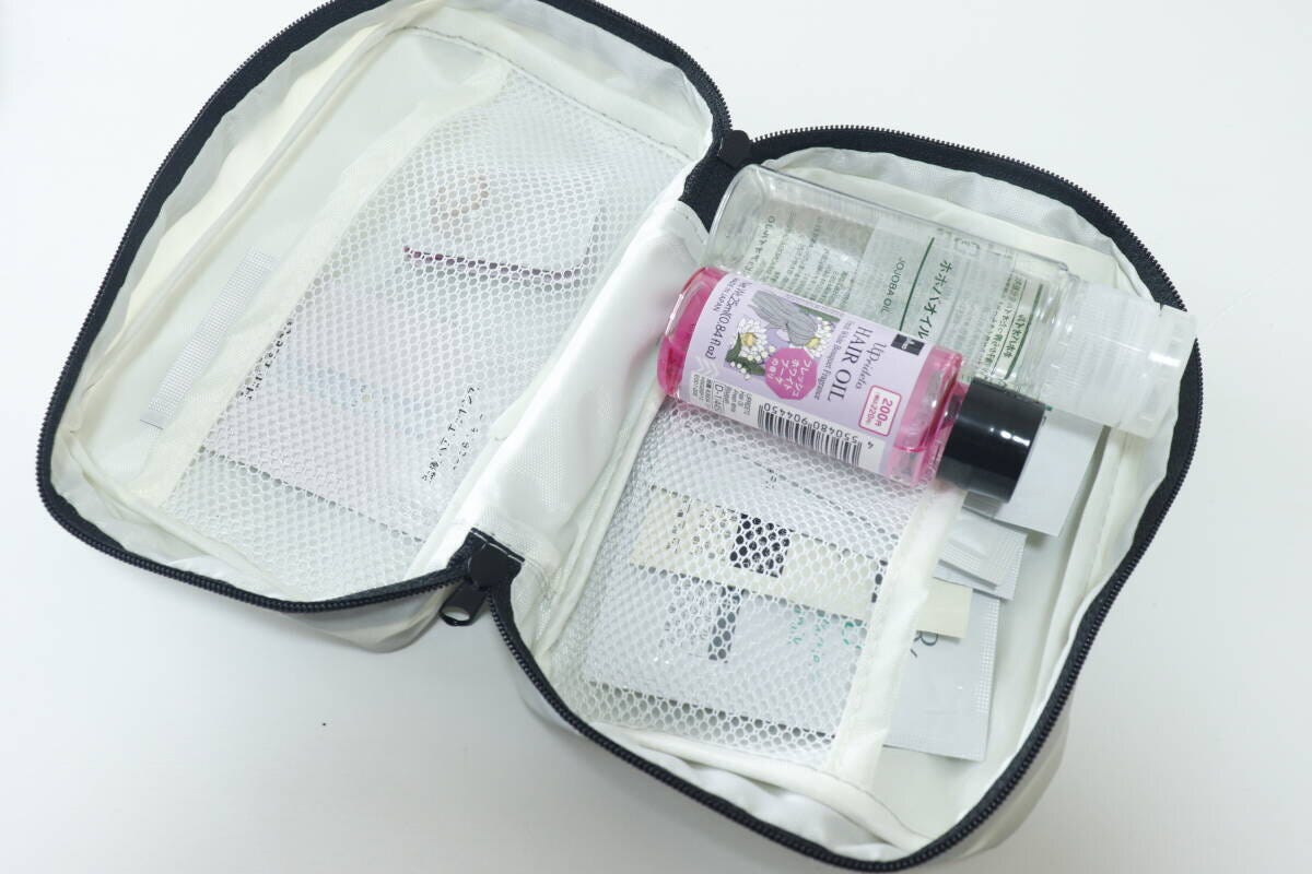 グレーのポーチにサンプルコスメやヘアオイルを収納している様子