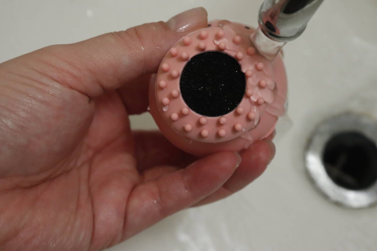 洗顔ブラシの底面に水道の蛇口から水がかけられている様子 洗顔ブラシの底面に水道の蛇口から水がかけられている様子