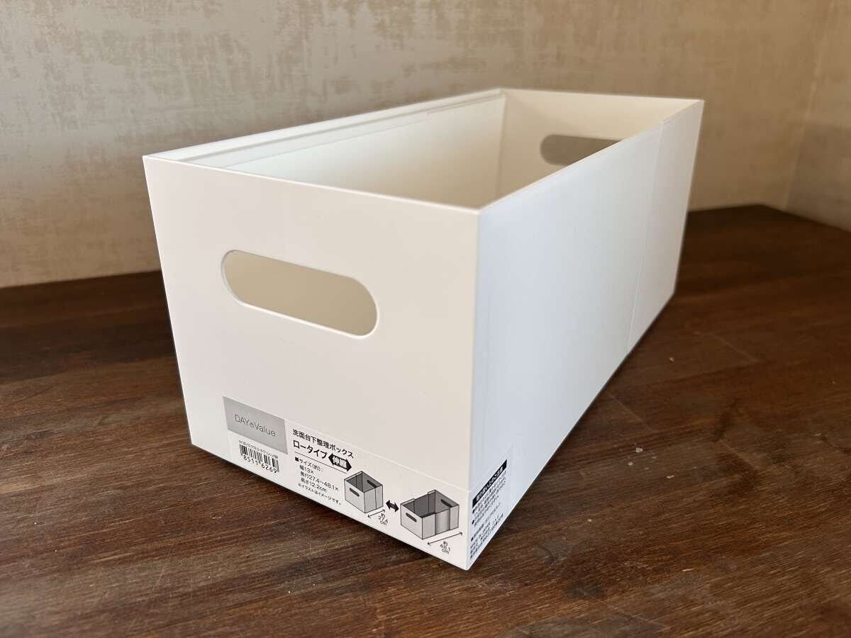 白い伸縮式の整理ボックスが木目の床に置かれ商品ラベルが見える