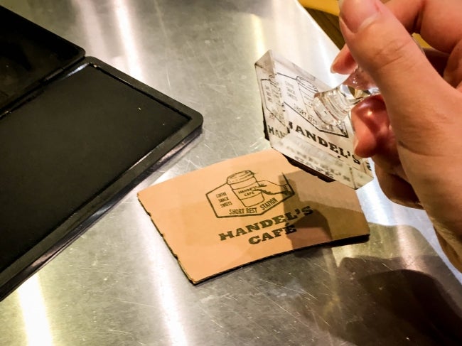 カップのスリーブはスタッフが1つ1つスタンプを押すことでコストカット／画像提供：フレックス