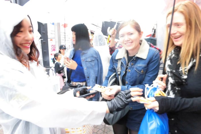 ほのちぃ、街行く人にお菓子を配る(画像提供:HSP)