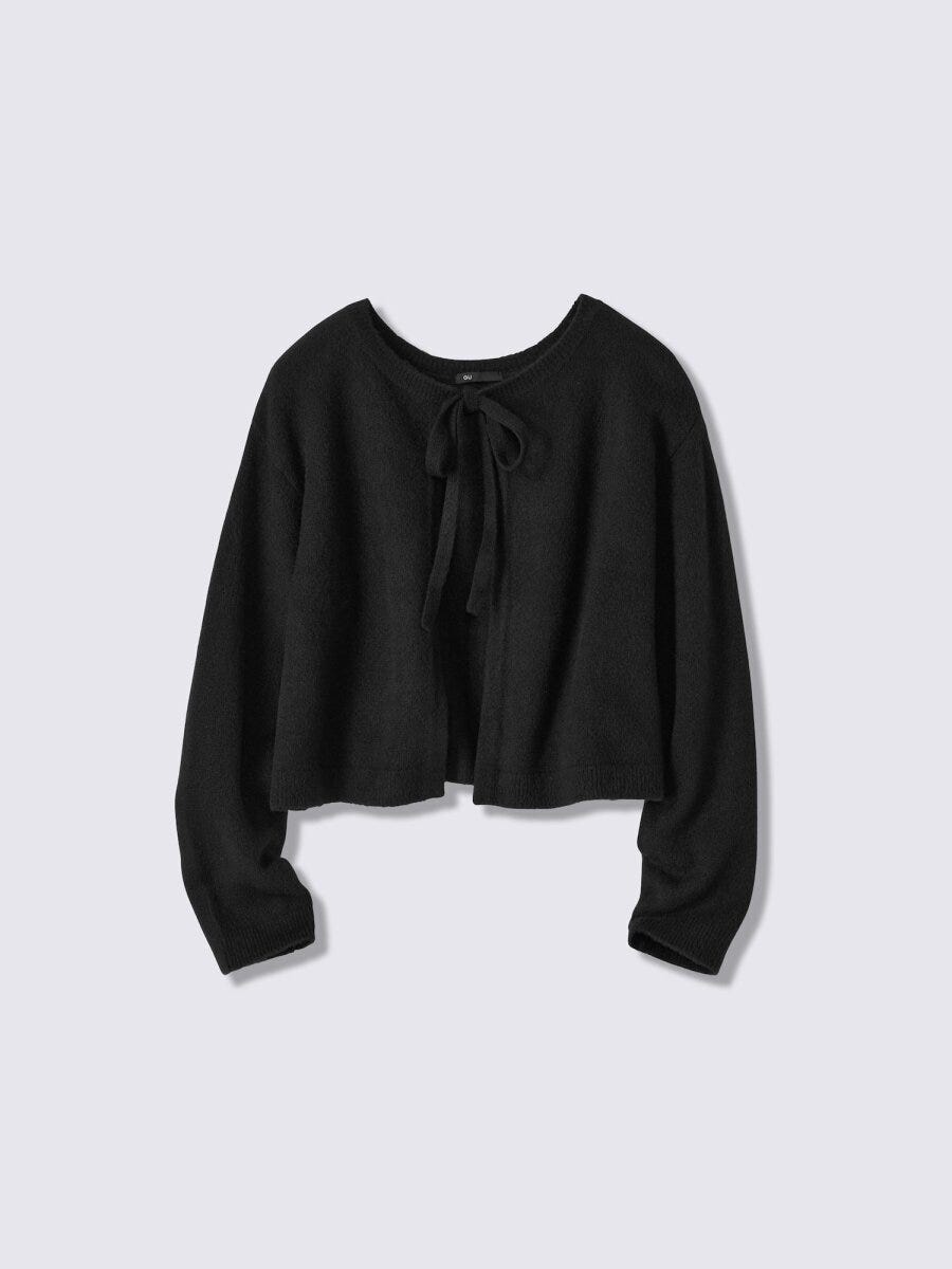 黒いリボン付きショート丈カーディガンが平置きされている
