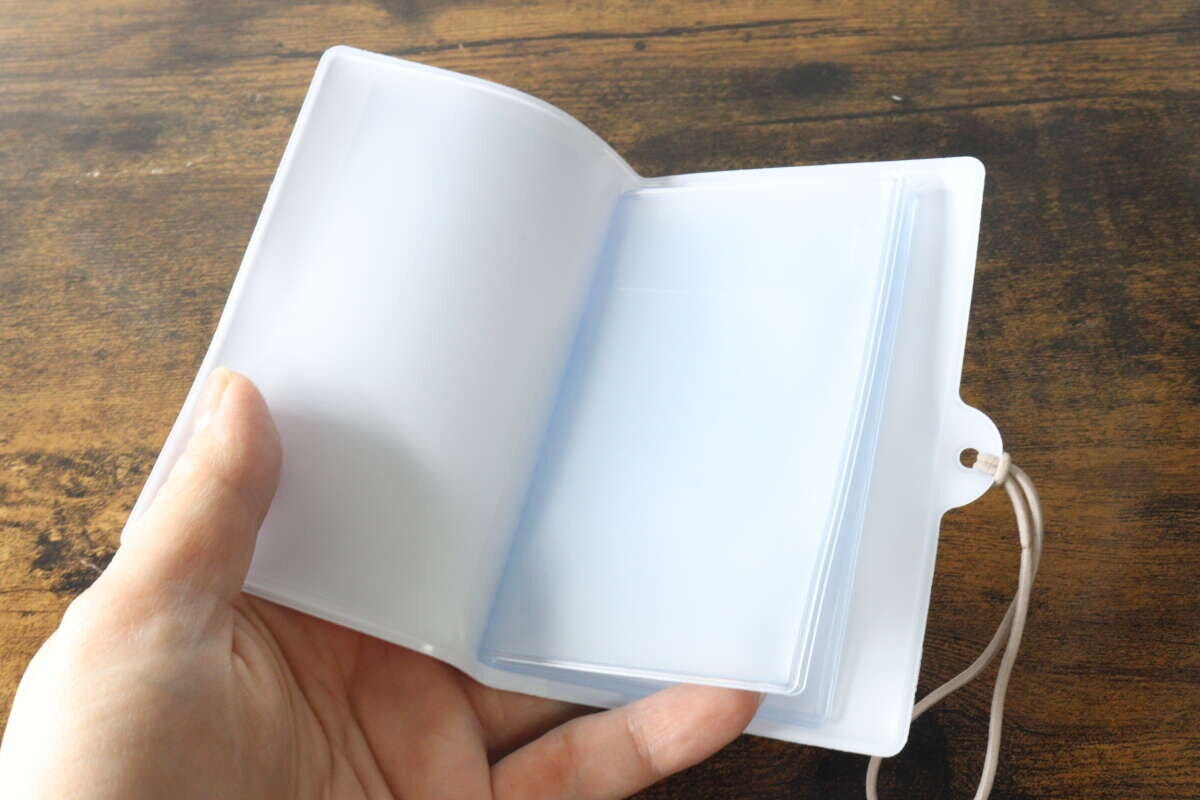 マルチホルダーを開き透明なフラップ付きポケットを見せている マルチホルダーを開き透明なフラップ付きポケットを見せている