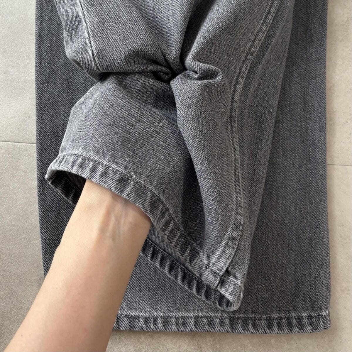 女性の手がグレーデニムの柔らかい生地感を確かめている