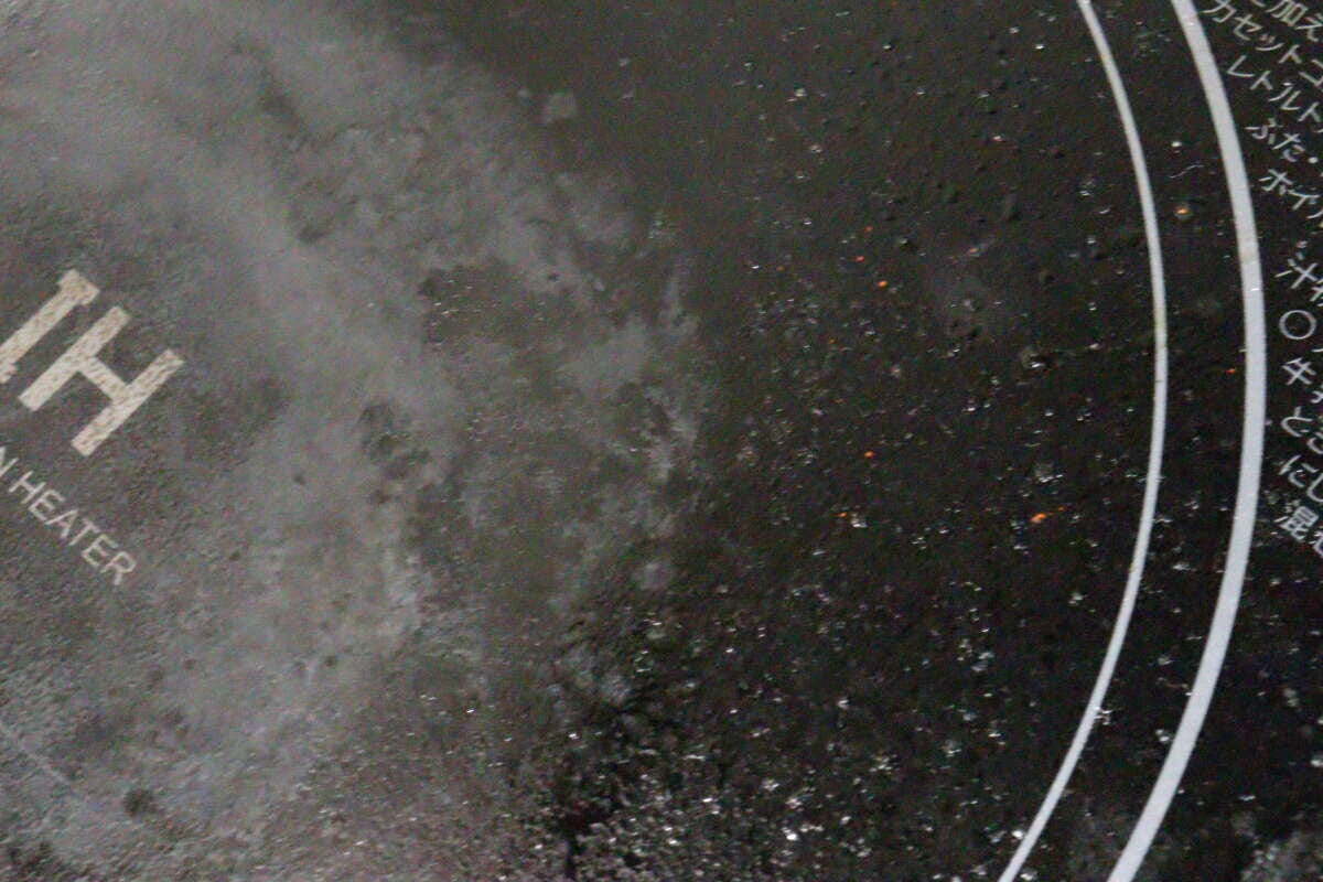 広範囲に油汚れが飛び散ったIHコンロの黒い天板