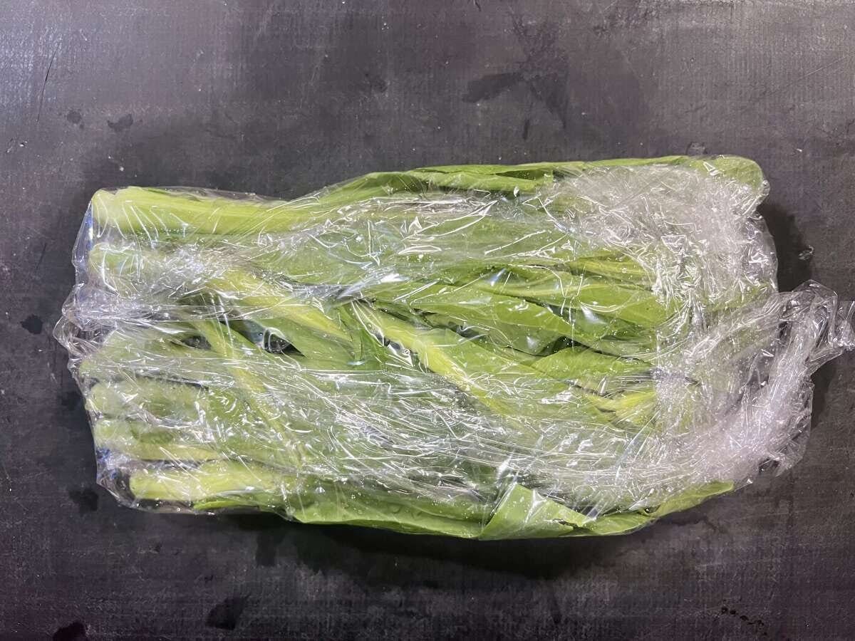 菜の花を濡れたままラップで包んだ電子レンジ加熱前の状態の俯瞰写真