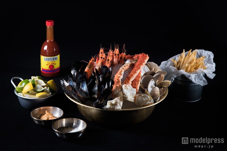 ボイルしたシーフードをクラッシュアイスに盛り付けた「コールドシーフードプラッター」とフレンチフライ「トリュフフレーバーフライ」／画像提供：DANCING CRAB