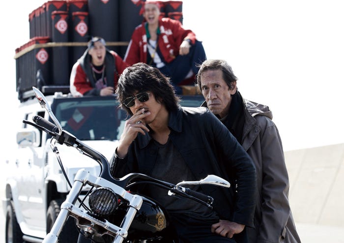 琥珀(AKIRA)と背後に謎の男性(斎藤洋介)(C)2017「HiGH&LOW」製作委員会