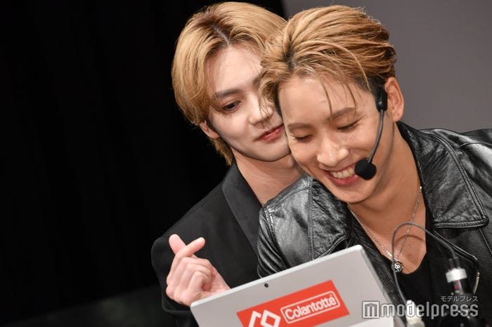 血流速度をチェックする陣の後ろでそっと指ハートする吉野北人(C)モデルプレス