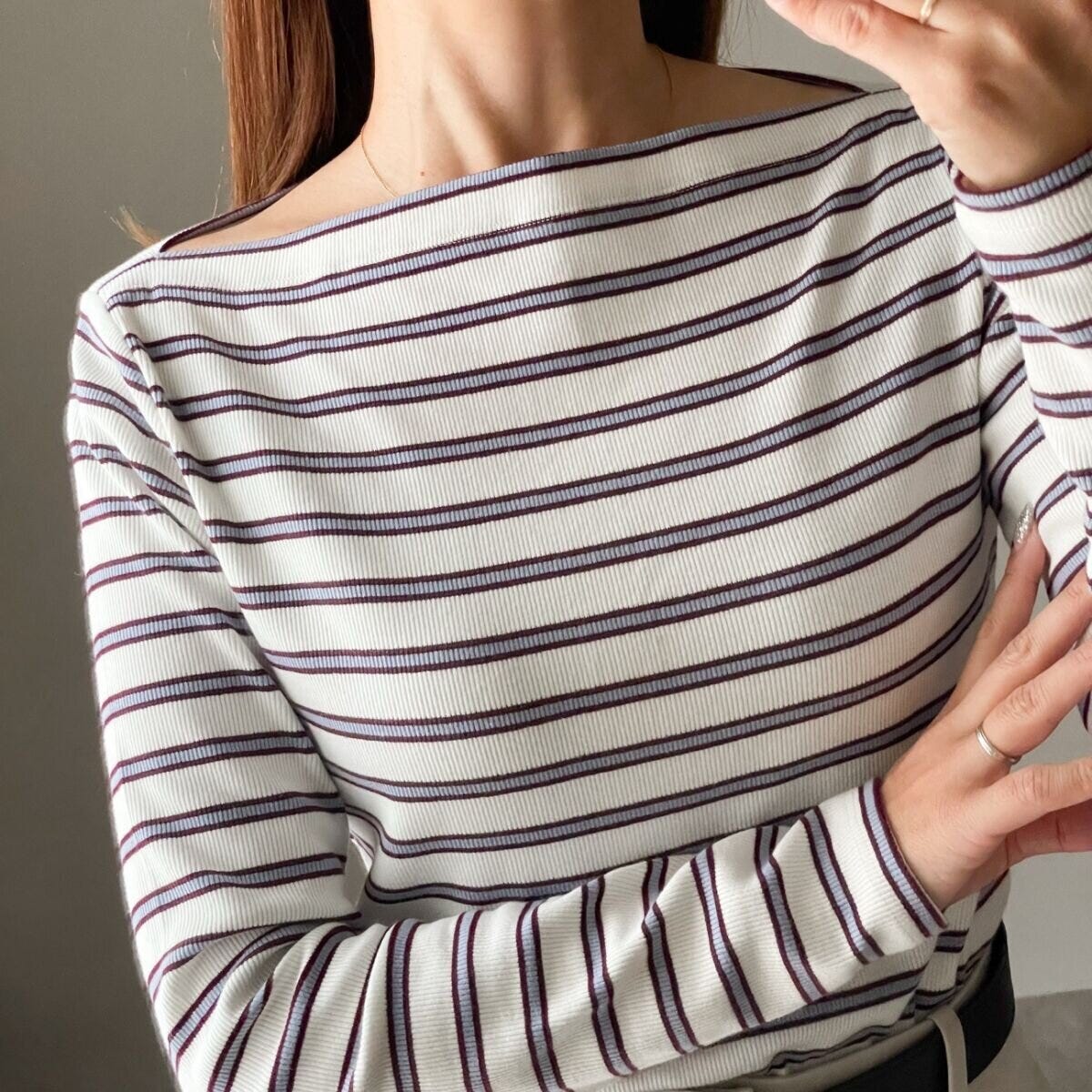 白地にアイスブルーとダークブラウンのボーダーTシャツのボートネック部分と鎖骨が見える女性の胸元アップ