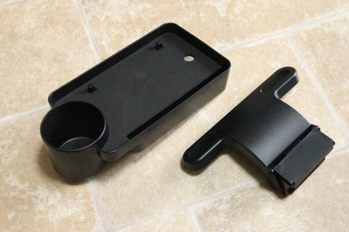 黒い車用トレイとヘッドレスト固定パーツが床に置かれている 黒い車用トレイとヘッドレスト固定パーツが床に置かれている