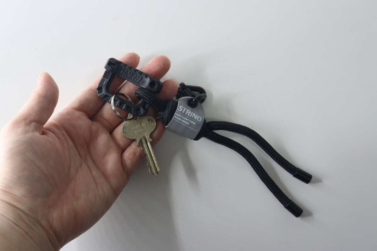 女性の手のひらにストラップキーホルダーと複数の鍵が乗っている状態