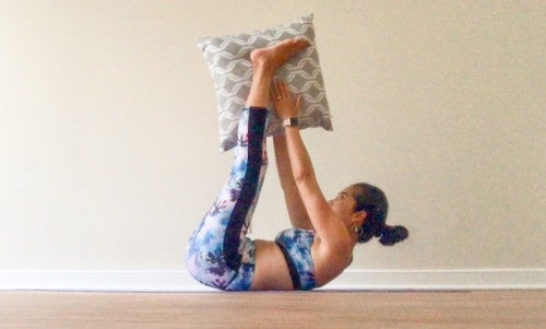 息を吐きながら両手両足を同時に持ち上げて、クッションもしくは枕を両足に渡すようにします。