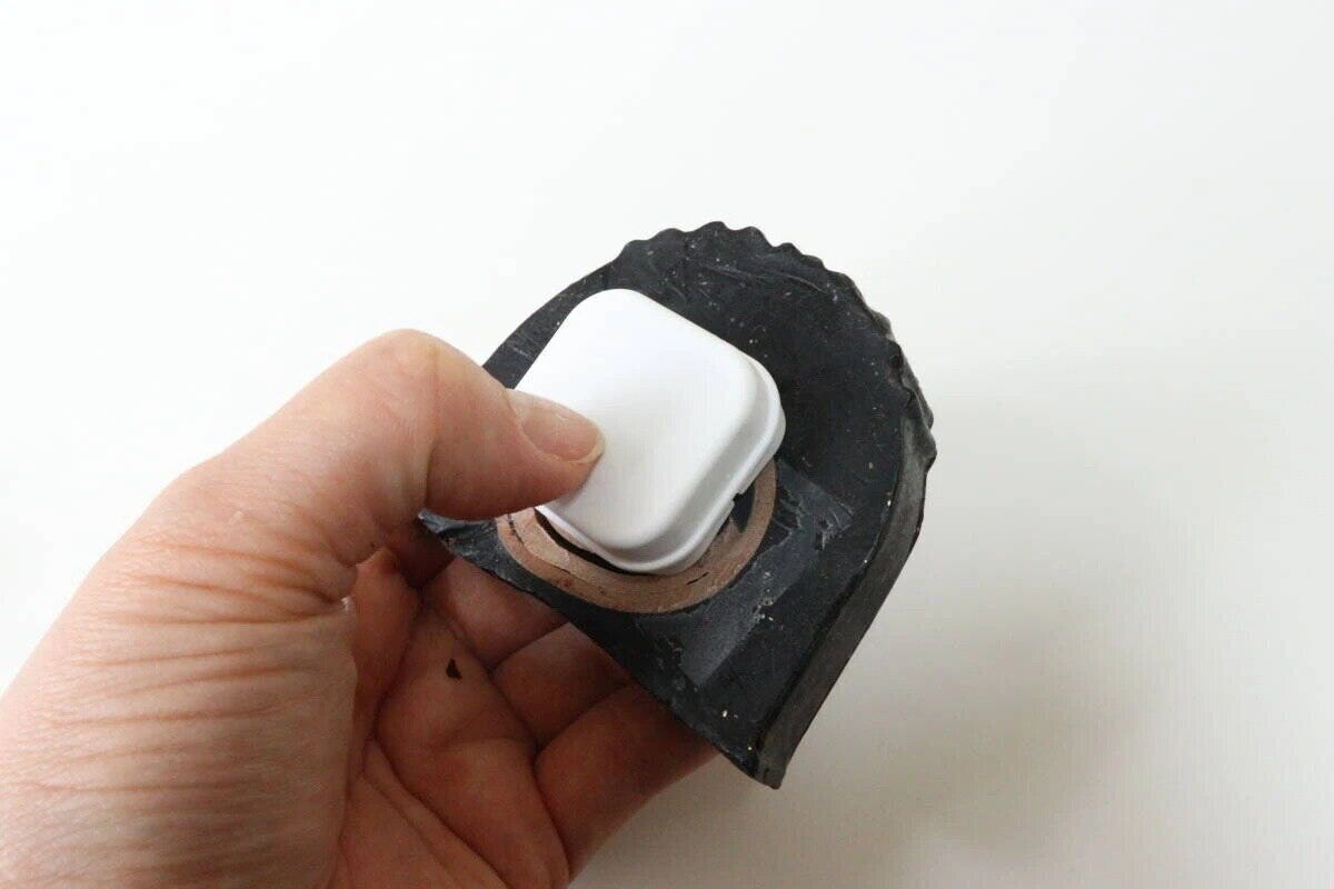 手が白い石けんホルダーを黒い石けんに埋め込んでいる 手が白い石けんホルダーを黒い石けんに埋め込んでいる