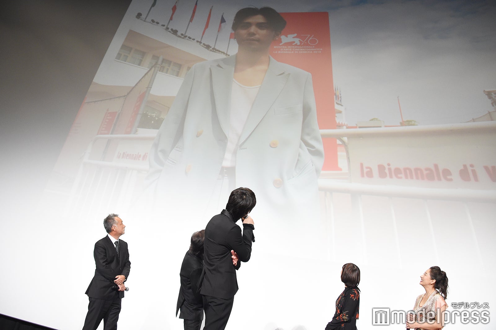 映画『楽園』でヴェネチア国際映画祭に参加した村上虹郎（スクリーン）の写真を観て、「主演たる感じでいいよね。かっこいい」とコメントする綾野剛（手前） （C）モデルプレス