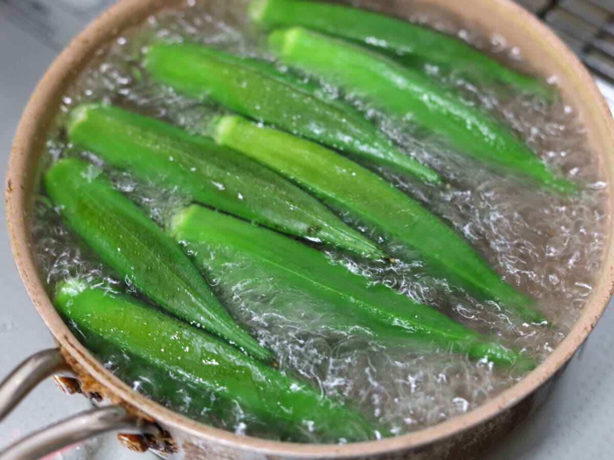 鍋で沸騰したお湯の中で茹でられているたくさんのオクラ 鍋で沸騰したお湯の中で茹でられているたくさんのオクラ