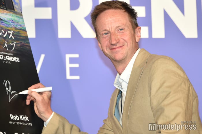 サイン前にカメラアピールするロブ・カーク氏(C)モデルプレス